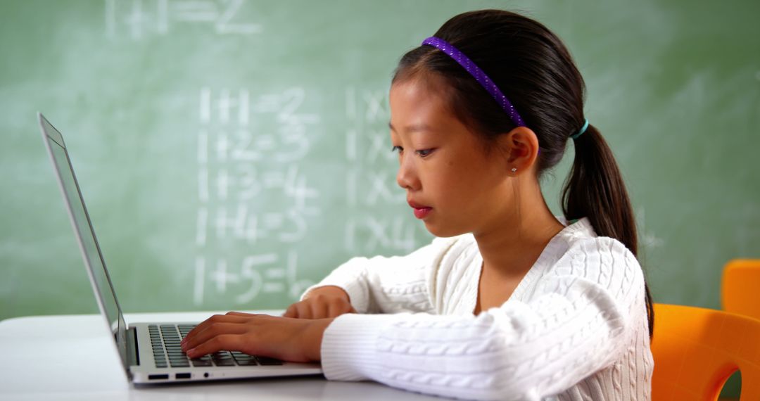 Diligent Schoolgirl Typing on Laptop in Classroom - Free Images, Stock Photos and Pictures on Pikwizard.com