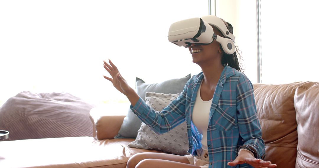Joyful Woman Immersed in Virtual Reality Experience on Couch
