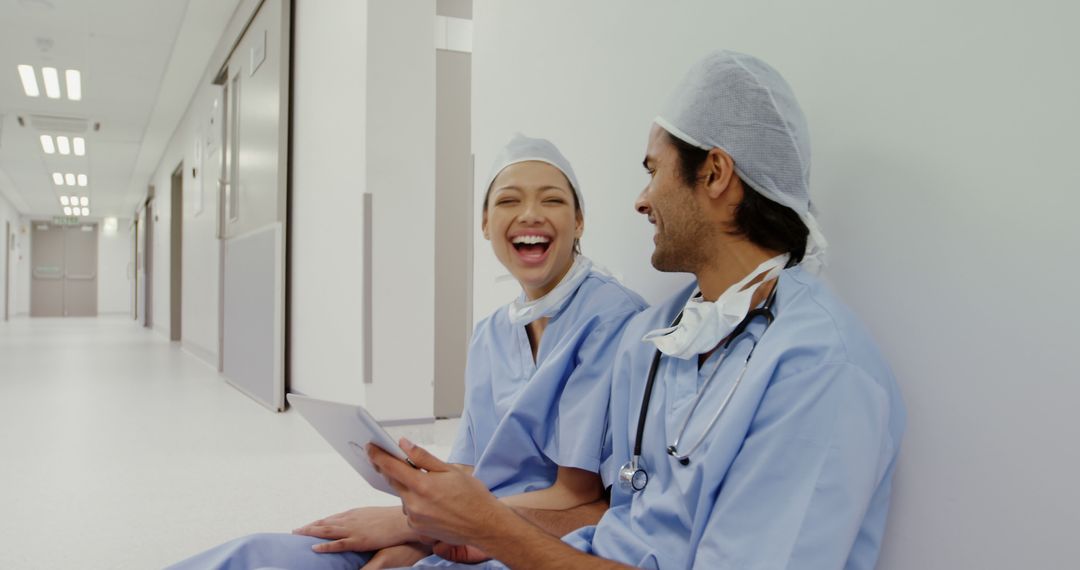 Smiling Medical Professionals Taking a Break in Hospital Corridor - Free Images, Stock Photos and Pictures on Pikwizard.com