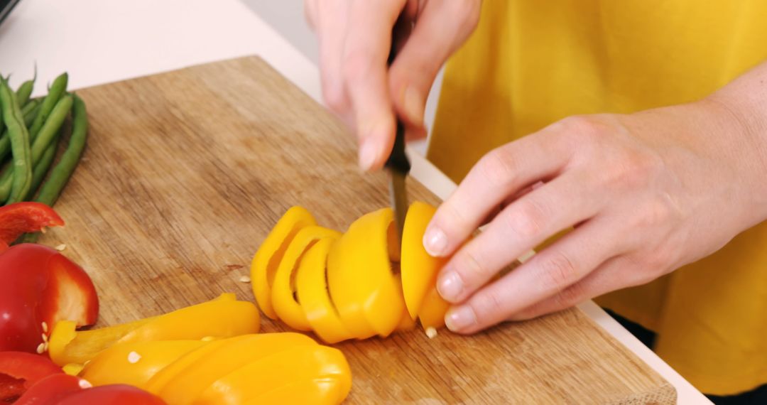 Person Chopping Yellow Bell Peppers on Wooden Cutting Board - Free Images, Stock Photos and Pictures on Pikwizard.com