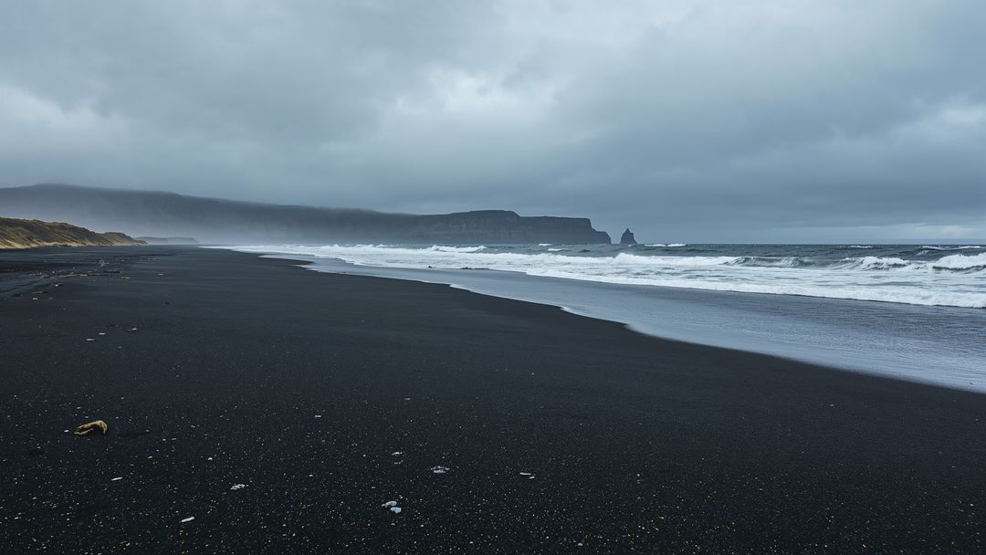 Majestic Black Sand Beach with Rolling Waves and Distant Cliffs