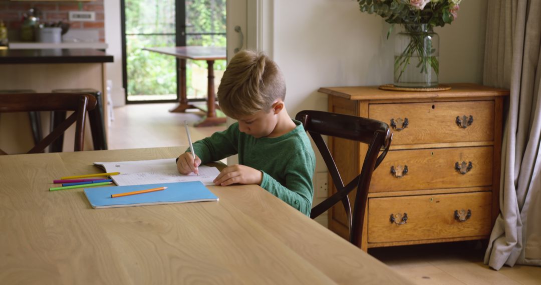 Young Boy Drawing at Wooden Table in Cozy Home Interior - Free Images, Stock Photos and Pictures on Pikwizard.com