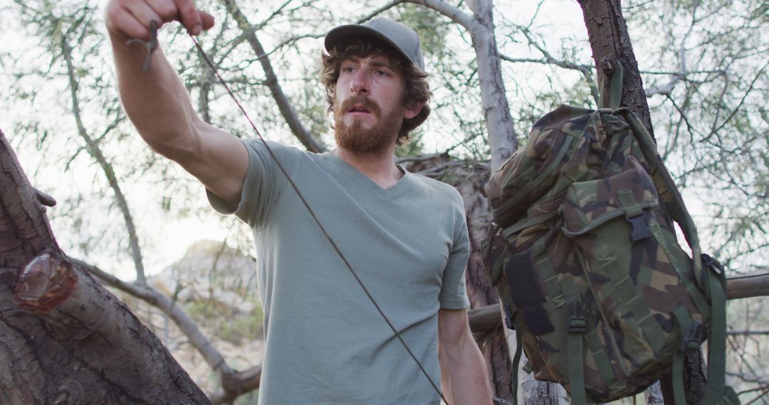 Bearded Survivor Unraveling Paracord in Wilderness Camp - Free Images, Stock Photos and Pictures on Pikwizard.com