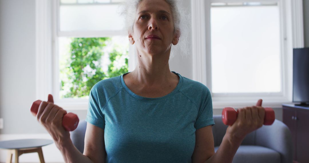 Senior Woman Exercising with Dumbbells at Home for Healthy Lifestyle - Free Images, Stock Photos and Pictures on Pikwizard.com