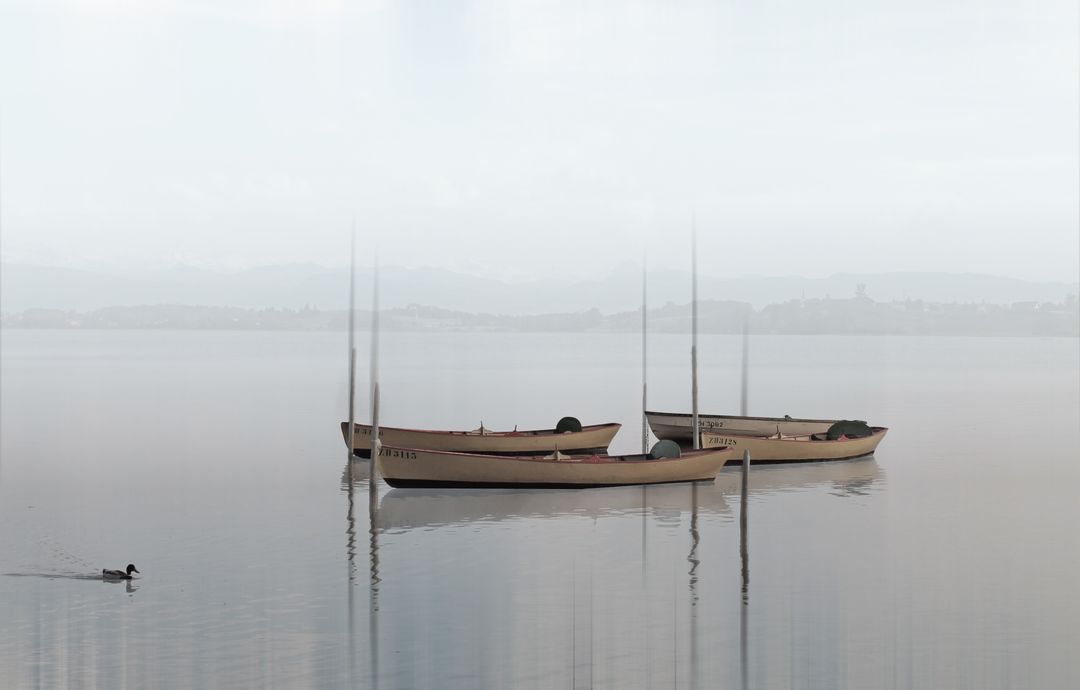 Serene Lake with Boats Floating in Morning Mist - Free Images, Stock Photos and Pictures on Pikwizard.com