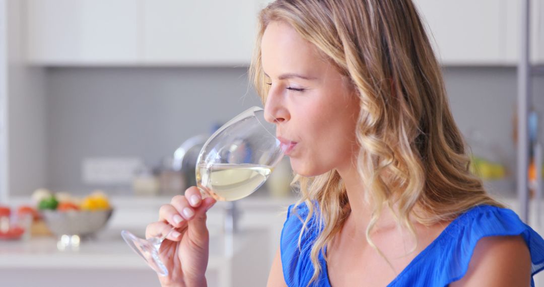 Woman Enjoying Glass of White Wine in Modern Kitchen - Free Images, Stock Photos and Pictures on Pikwizard.com