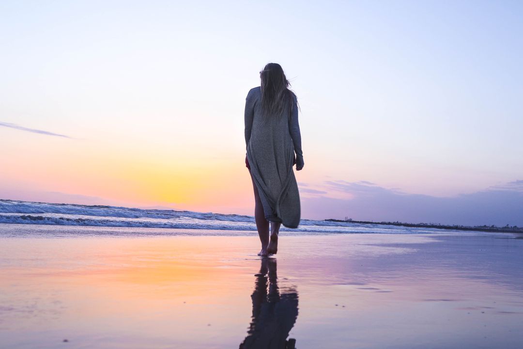 Woman Strolling Beach at Sunset