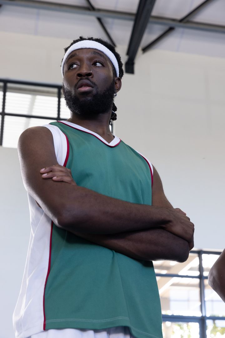 Confident Basketball Player in Gym Standing Firm with Crossing Arms