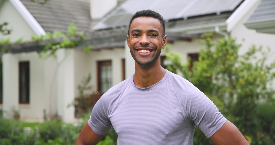 Smiling Man Outdoors Near Eco-Friendly Modern Home