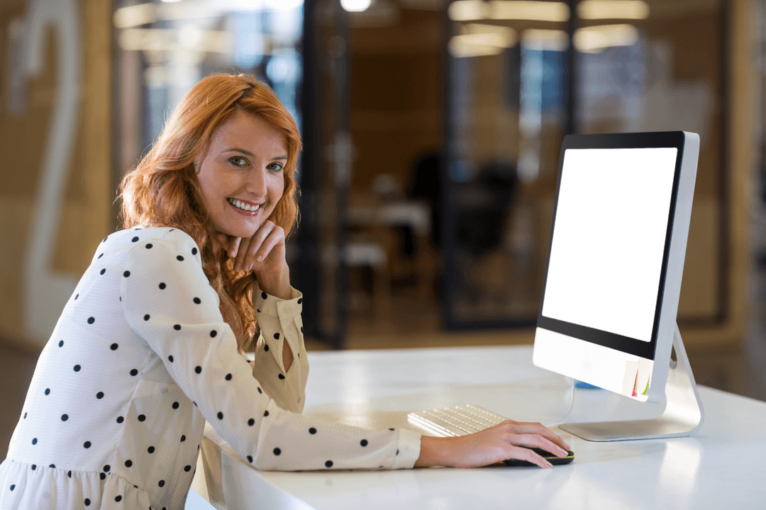 Professional Woman Smiling at Computer Desk in Modern Office