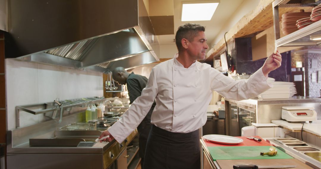 Professional Chef Inspects Dish in Busy Restaurant Kitchen - Free Images, Stock Photos and Pictures on Pikwizard.com