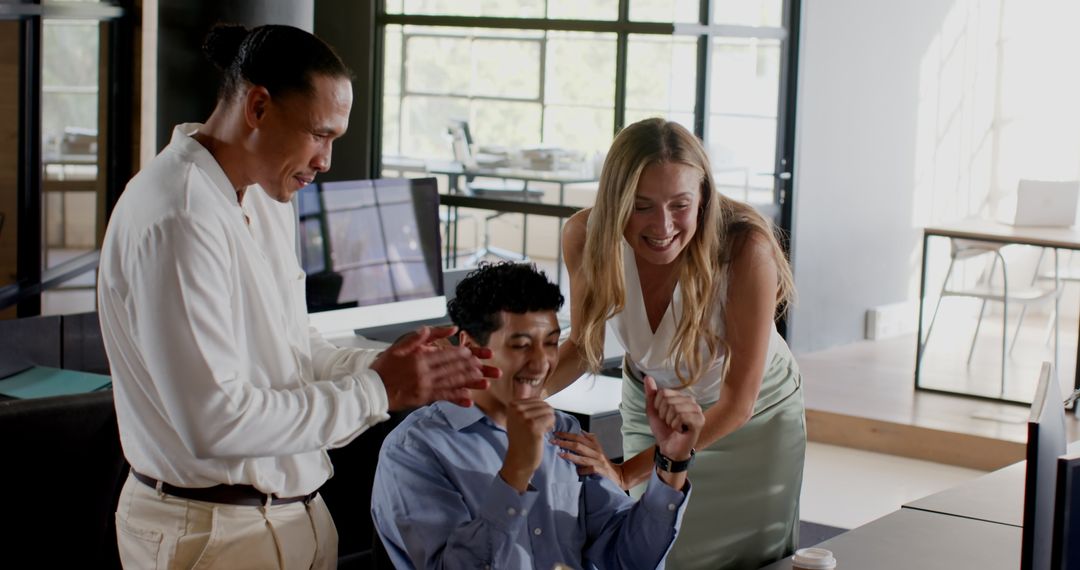 Excited Team Celebrating Success at Office Workstation