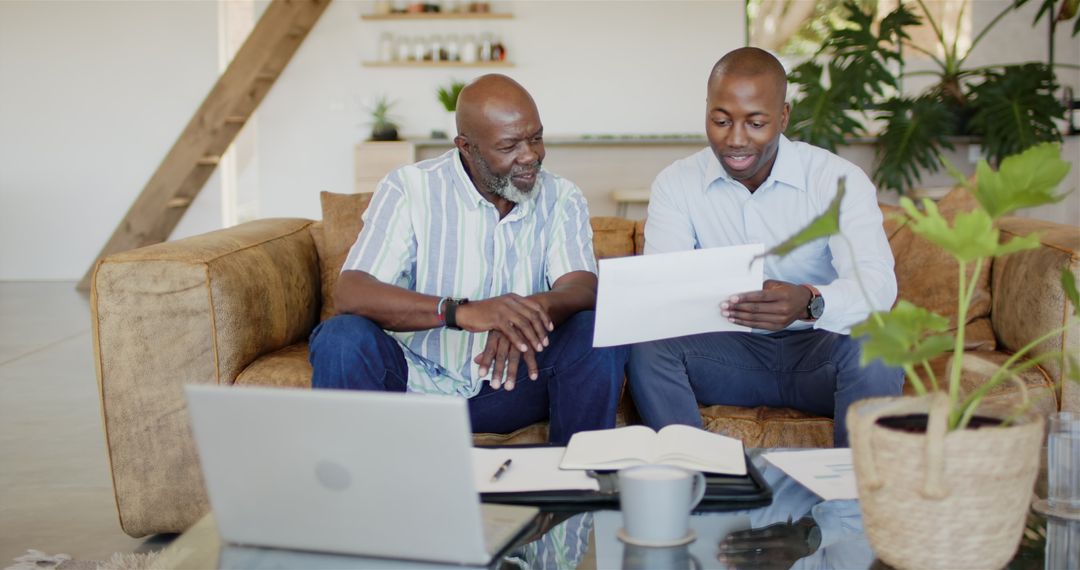 Financial Advisor Discussing Documents with Client on Sofa