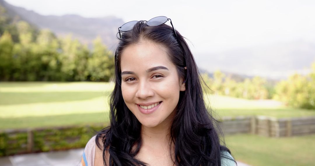 Smiling Woman with Sunglasses Relaxing in Sunny Park