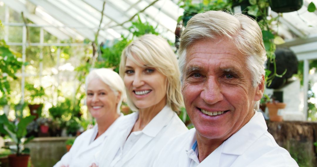 Smiling Botanists Working in Lush Greenhouse - Free Images, Stock Photos and Pictures on Pikwizard.com