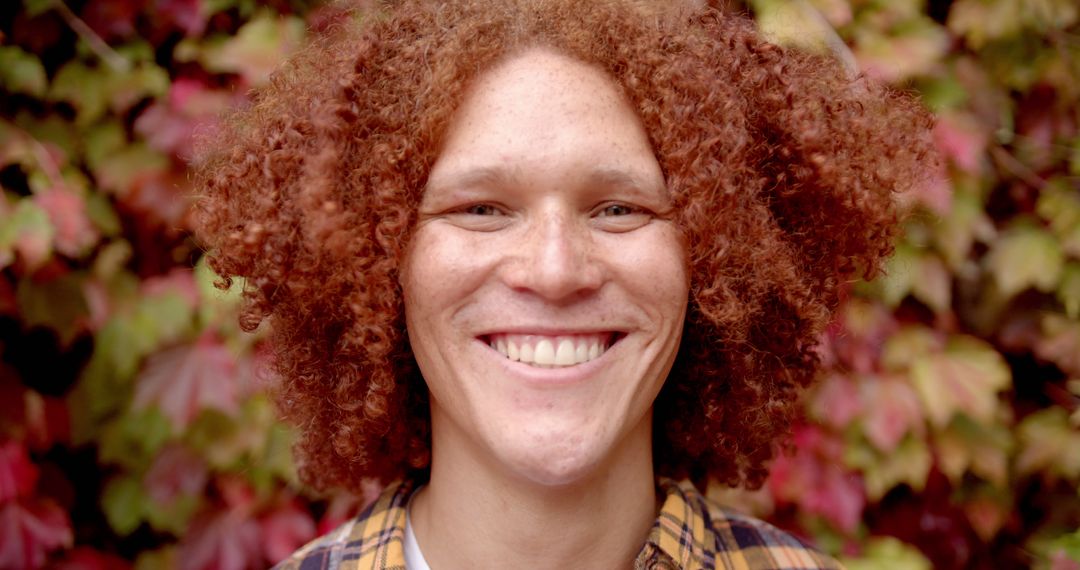 Portrait of happy diverse man with red curly hair standing and smiling in sunny garden - Free Images, Stock Photos and Pictures on Pikwizard.com