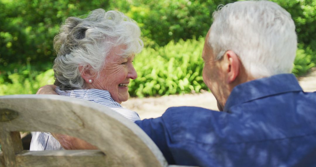 Senior Couple Embracing on Bench in Sunlit Garden