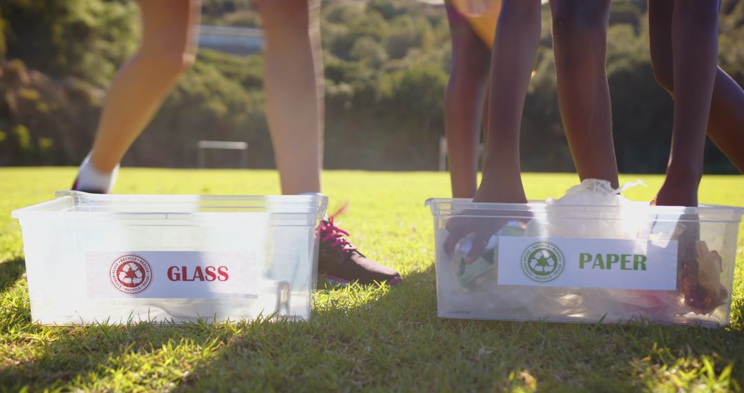 Girls Sorting Recyclables into Glass and Paper Bins Outdoors