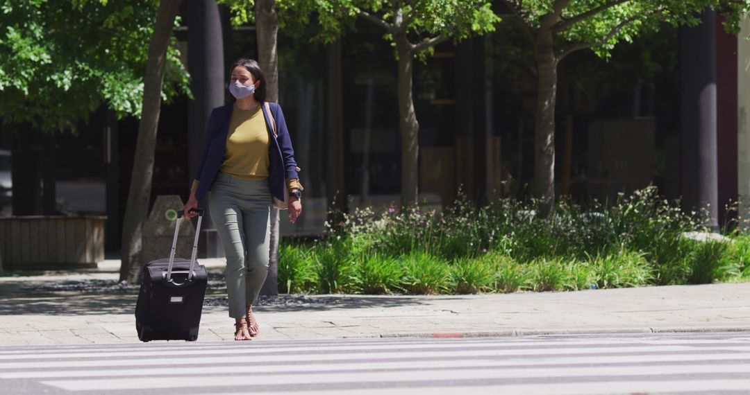 Woman Traveling With Suitcase Wearing Mask Outdoors - Free Images, Stock Photos and Pictures on Pikwizard.com