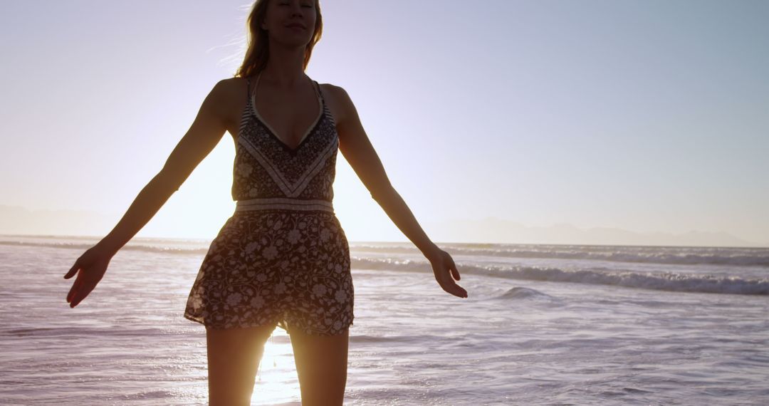 Woman embracing sunset at beach, feeling peaceful - Free Images, Stock Photos and Pictures on Pikwizard.com