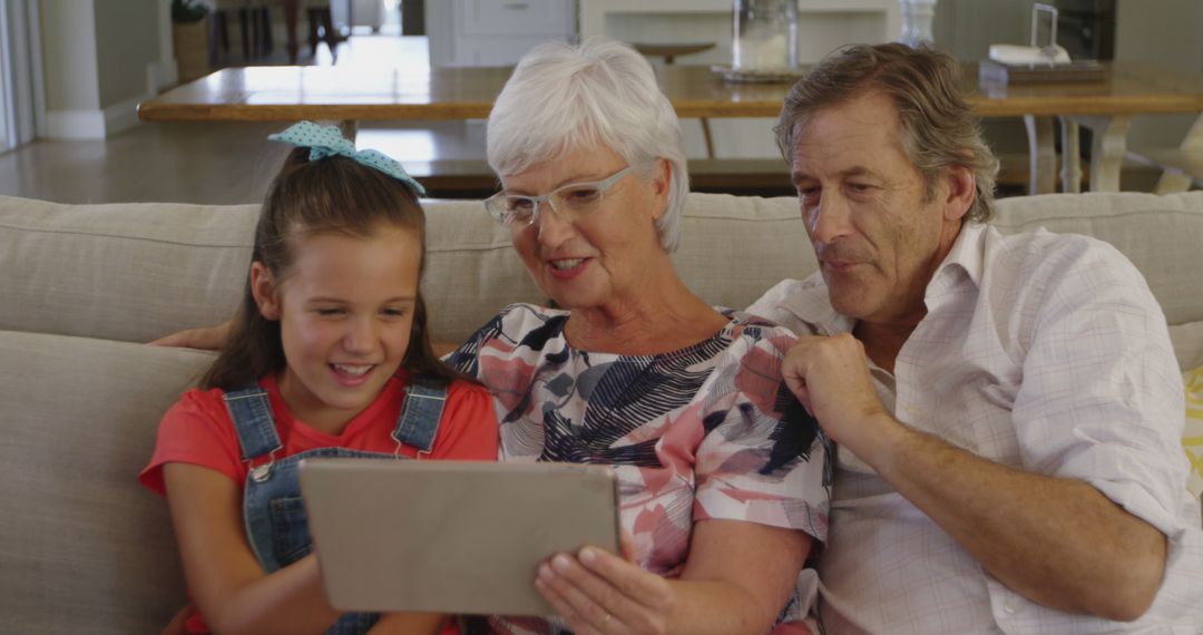 Happy Grandparents and Granddaughter Using Tablet at Home - Free Images, Stock Photos and Pictures on Pikwizard.com