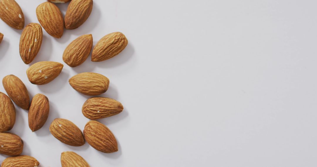 Raw Almonds Scattered on White Background for Healthy Eating