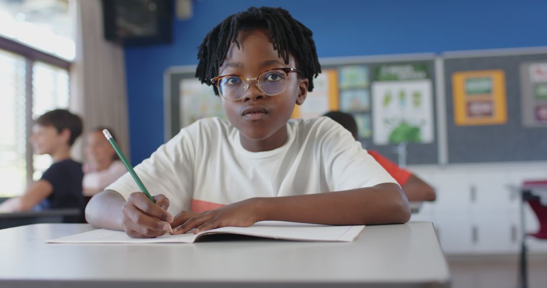 Focused Schoolboy Writing in Classroom Notebook Engagement