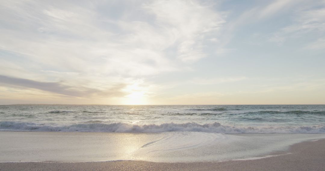 Tranquil Beach with Ocean Waves at Sunset