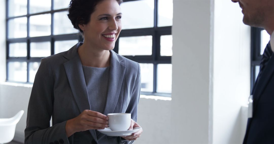 Professional Woman Holding Coffee Cup Engaging in Conversation - Free Images, Stock Photos and Pictures on Pikwizard.com