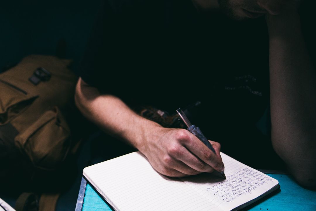 Reflective Person Writing Thoughtful Journal at Night
