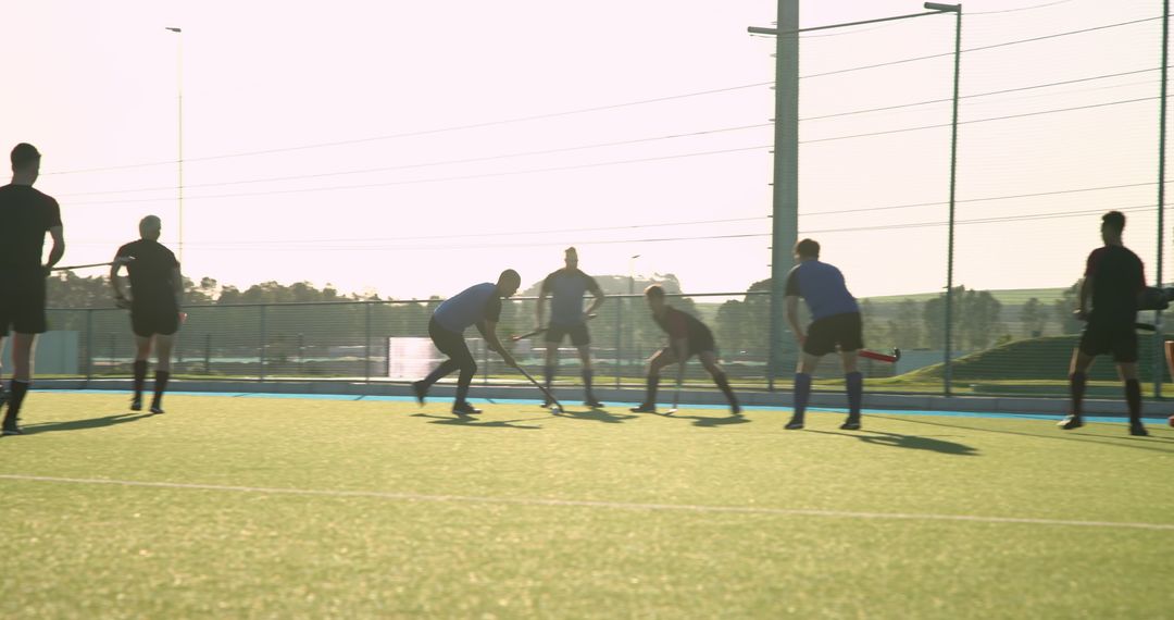 Dynamic Field Hockey Match on Synthetic Turf at Sunset
