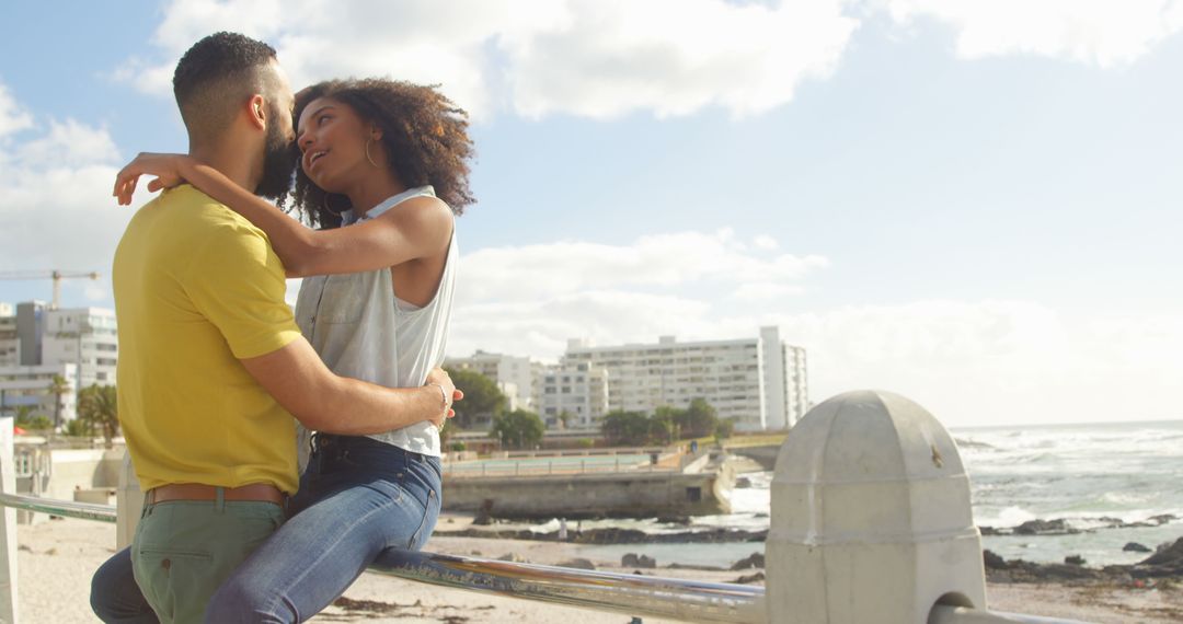 Young Couple Embracing by Oceanside Urban Landscape - Free Images, Stock Photos and Pictures on Pikwizard.com