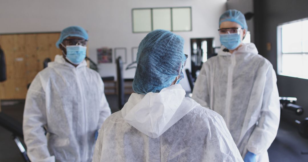 Medical Professionals Wearing Protective Gear Having Discussion At Medical Facility - Free Images, Stock Photos and Pictures on Pikwizard.com