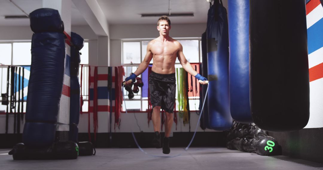 Shirtless Man Jump-Roping in Gym with Boxing Equipment - Free Images, Stock Photos and Pictures on Pikwizard.com