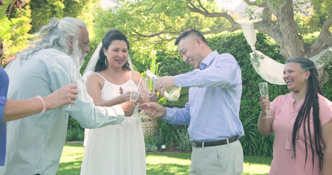 Senior Couple and Friends Toasting with Champagne in Garden
