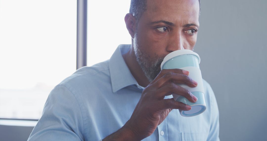 Man Drinking Coffee Near Window in Relaxed Consideration - Free Images, Stock Photos and Pictures on Pikwizard.com