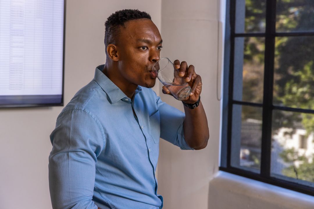Professional Man Refreshes Mind with Water at Office Workspace