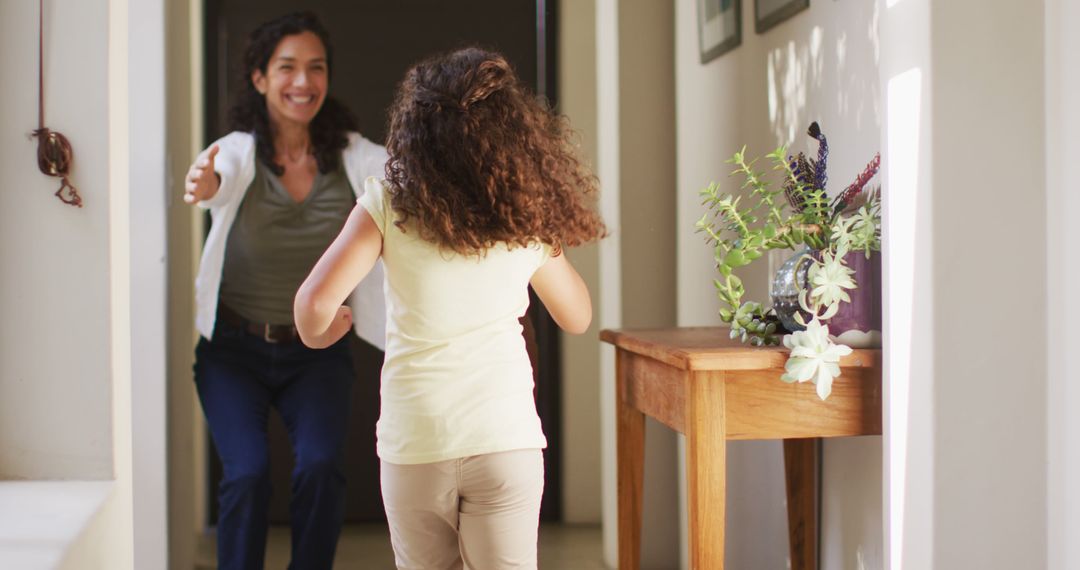 Mother joyfully welcoming daughter home in hallway - Free Images, Stock Photos and Pictures on Pikwizard.com