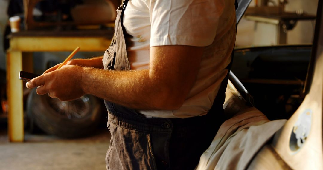 Mechanic Using Smartphone in Workshop - Free Images, Stock Photos and Pictures on Pikwizard.com