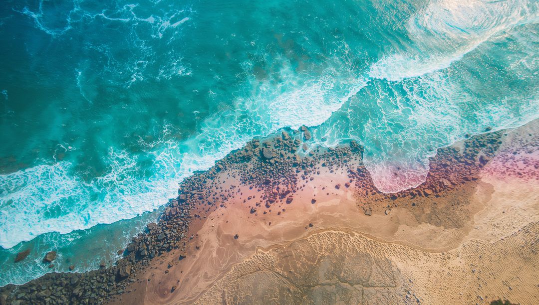 Aerial View of Turquoise Waves Crashing on Sandy Shoreline