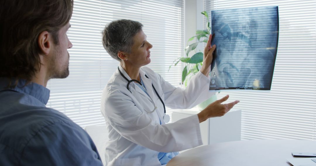 Doctor Reviewing X-Ray With Male Patient in Medical Office - Free Images, Stock Photos and Pictures on Pikwizard.com