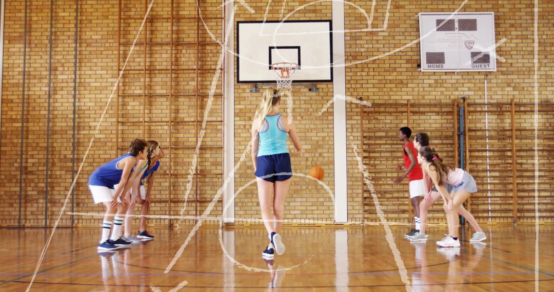 Young Athletes Practicing Basketball Plays in Gym