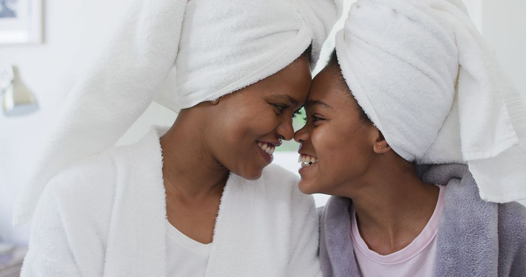 Mother and daughter bonding with towels on heads and smiles - Free Images, Stock Photos and Pictures on Pikwizard.com