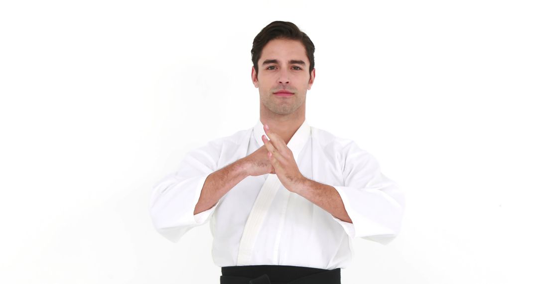 Male Martial Artist Showcasing Traditional Karate Pose in White Uniform - Free Images, Stock Photos and Pictures on Pikwizard.com