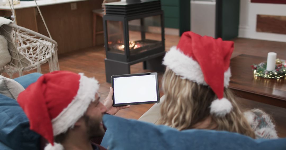 Couple Relaxing by Fireplace with Tablet on Christmas Eve - Free Images, Stock Photos and Pictures on Pikwizard.com