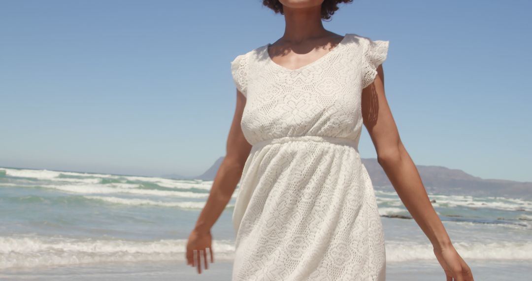 Woman in White Dress Enjoying Sunny Beach - Free Images, Stock Photos and Pictures on Pikwizard.com