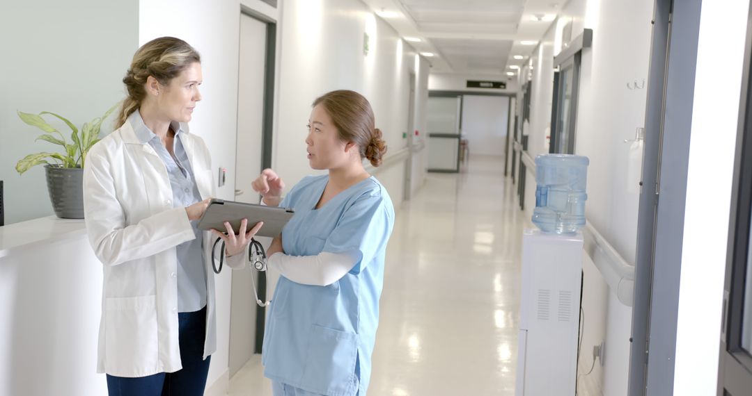 Doctors Discussing Medical Records In Hospital Hallway - Free Images, Stock Photos and Pictures on Pikwizard.com