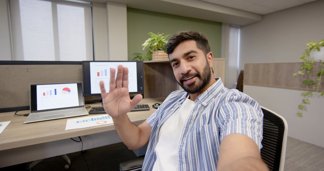 Employee Waving on Videocall at Modern Workspace