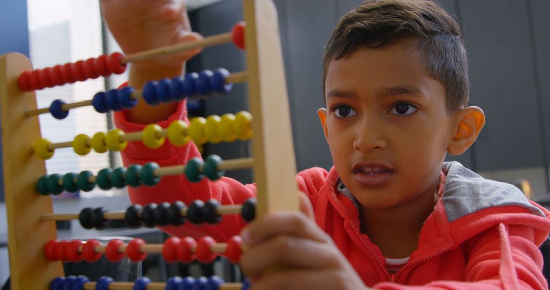 Focused Boy Using Abacus for Math Learning in Classroom