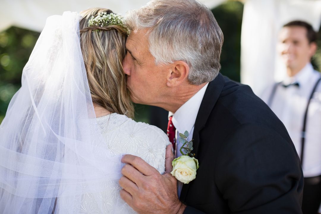 Father kissing bride during wedding ceremony - Free Images, Stock Photos and Pictures on Pikwizard.com
